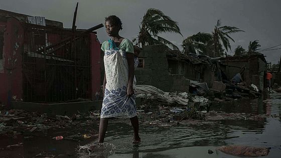 Eine Frau geht über eine durch Zyklon Idai verwüstete Straße in Beira.
