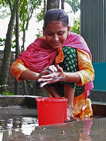 Eine Frau wäscht sich mit Seife die Hände.