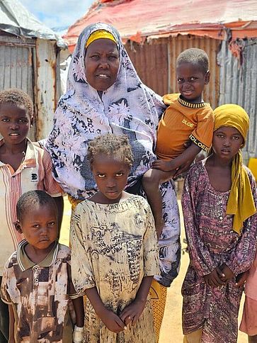 Fadumo mit ihrer Familie vor ihrer Unterkunft.