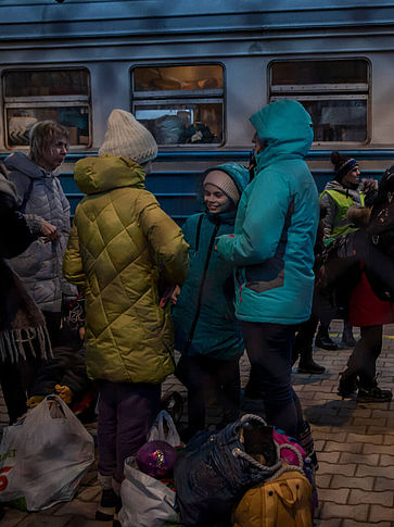 Geflüchtete aus der Ukraine stehen vor einem Zug in Polen