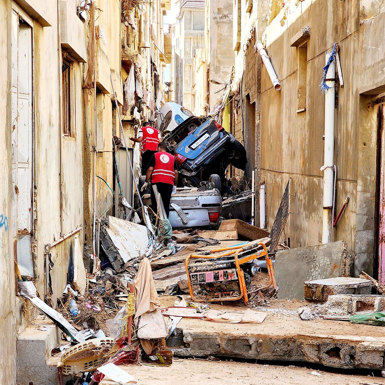 Zerstörte Autos und Straße Kraftfahrzeuge und eine enge Straße, die durch die Überschwemmungen in Libyen zerstört wurden.