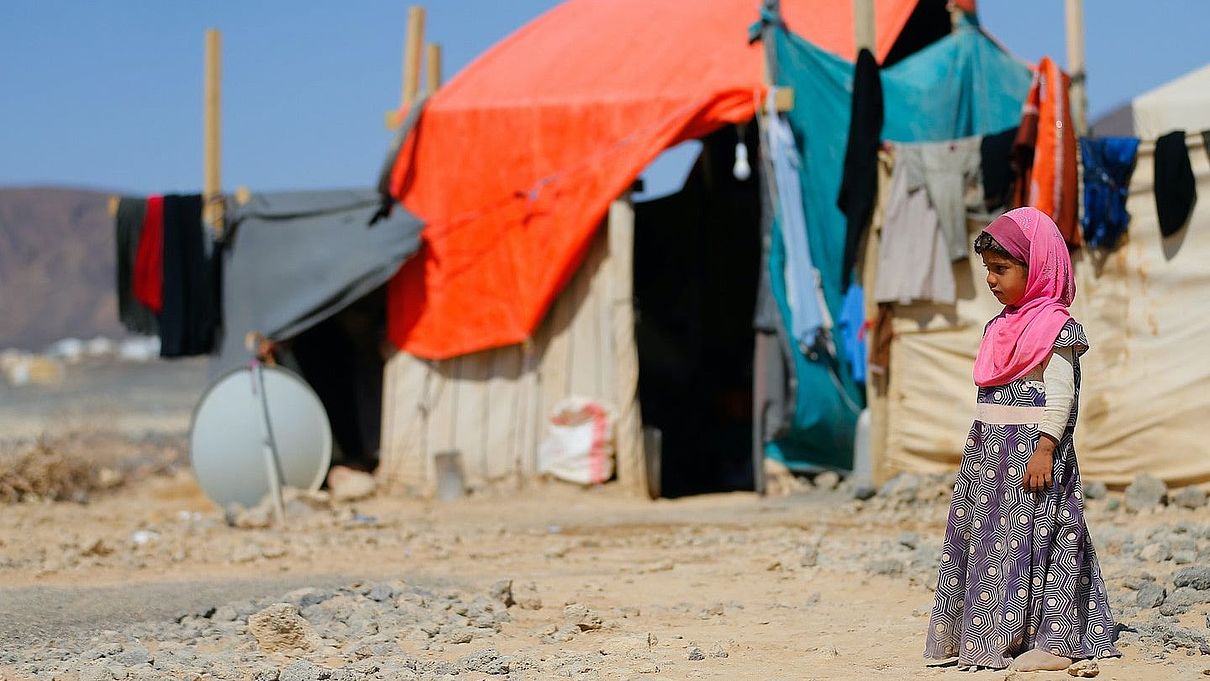 Ein kleines Mädchen im Jemen steht vor einem Zelt