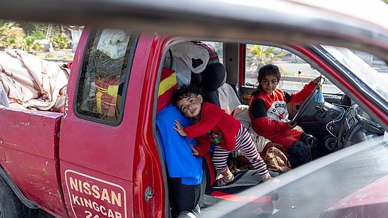 Zwei Kinder sind in einem voll beladenen Auto.