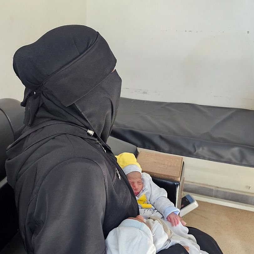 Batoul hält Zwillinge Batoul hält Zwillinge im Arm.