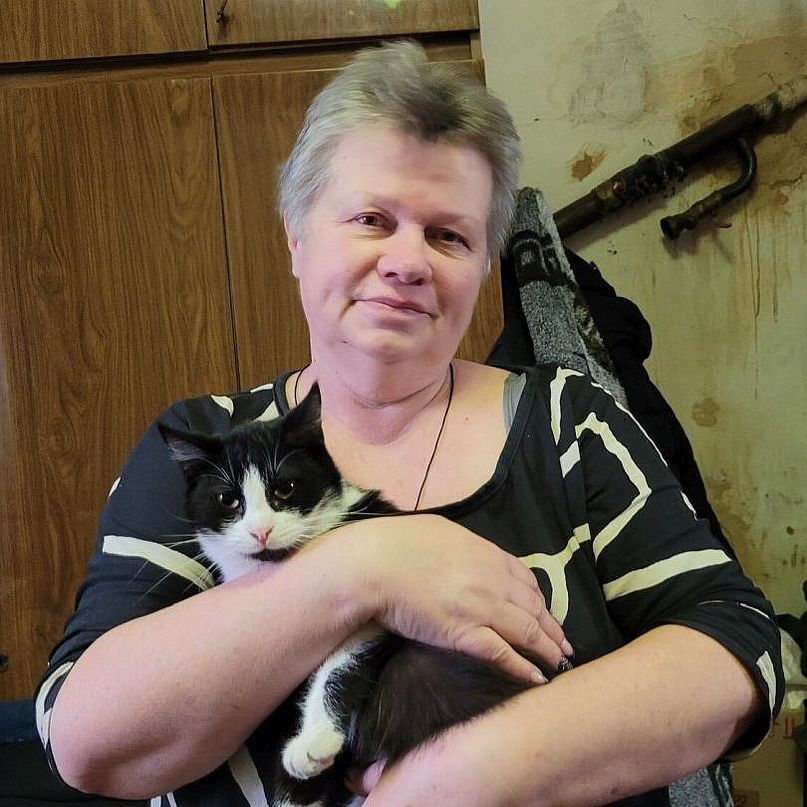 Olga hat eine Katz auf dem Arm.