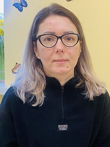 Lena sitzt auf einer Bank im Community Center.