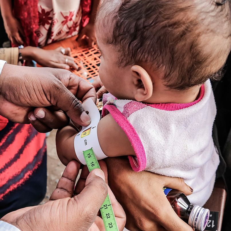 Ein Baby mit Hungerband um den Oberarm: Das Band ist im gelben Bereich