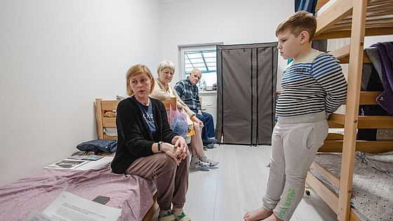 Natalia und ihre Familie in einem kleinen Zimmer in ihrer Notunterkunft.