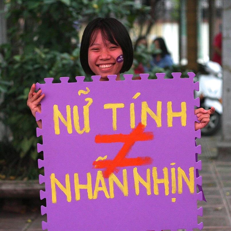 Eine junge Frau hält ein Protestschild gegen geschlechterbasierte Gewalt in den Händen