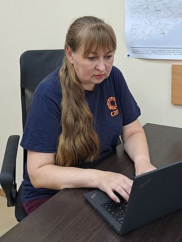 Irina sitzt in ihrem Büro und arbeitet an ihrem Laptop.