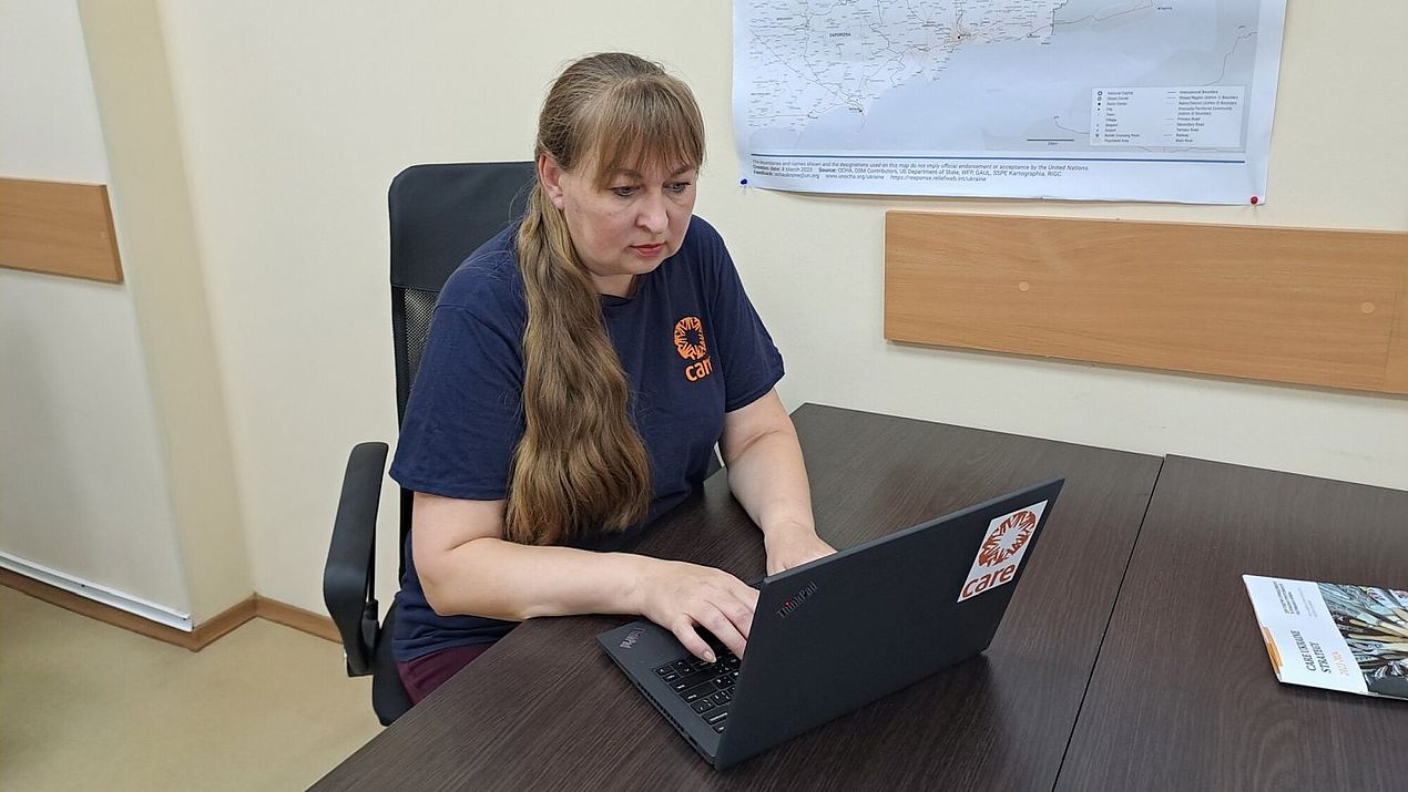 Irina sitzt in ihrem Büro und arbeitet an ihrem Laptop.