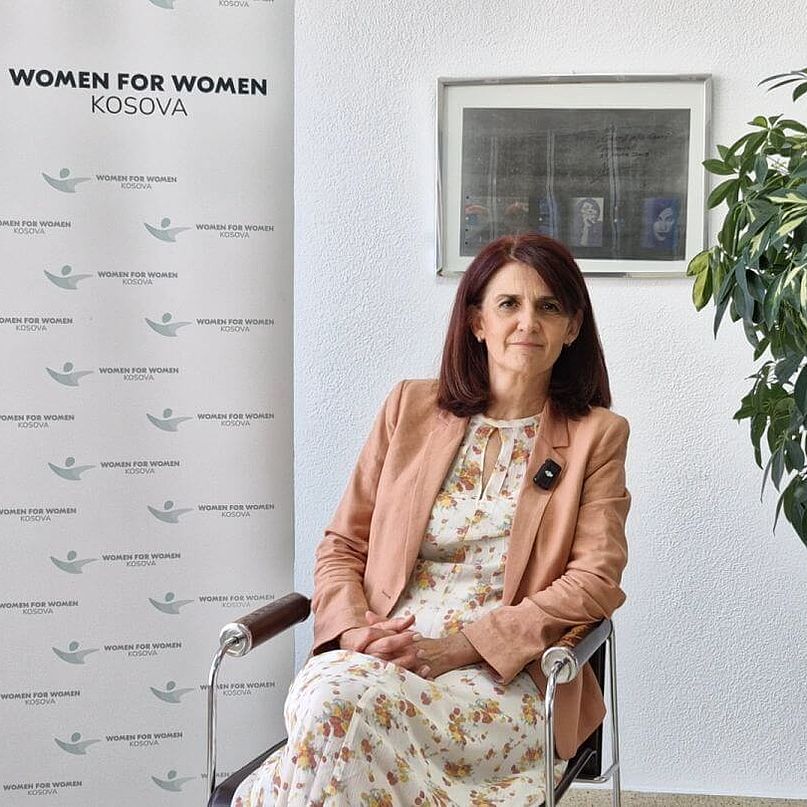 Portraitfoto von Iliriana Gashi von der CARE-Partnerorganisation Kosova - Women 4 Women in Pristina Iliriana Gashi sitzt in einem Buero und blickt in die Kamera.