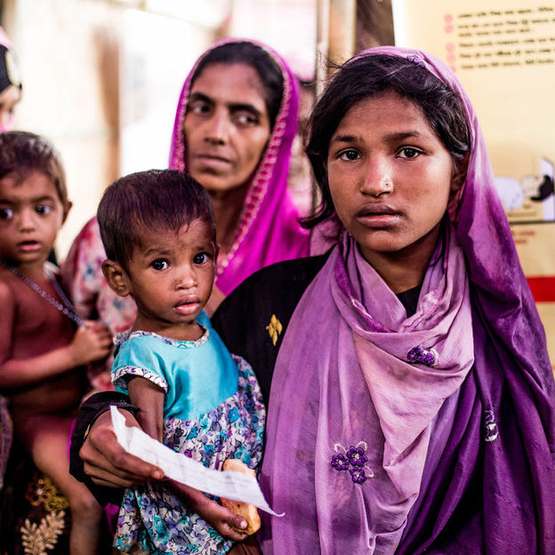 Im Flüchtlingscamp in Bangladesch trägt Hamida ihre mangelernährte Schwester Bushra auf dem Arm.