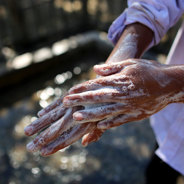 Ein Erwachsener wäscht sich die Hände mit Seife