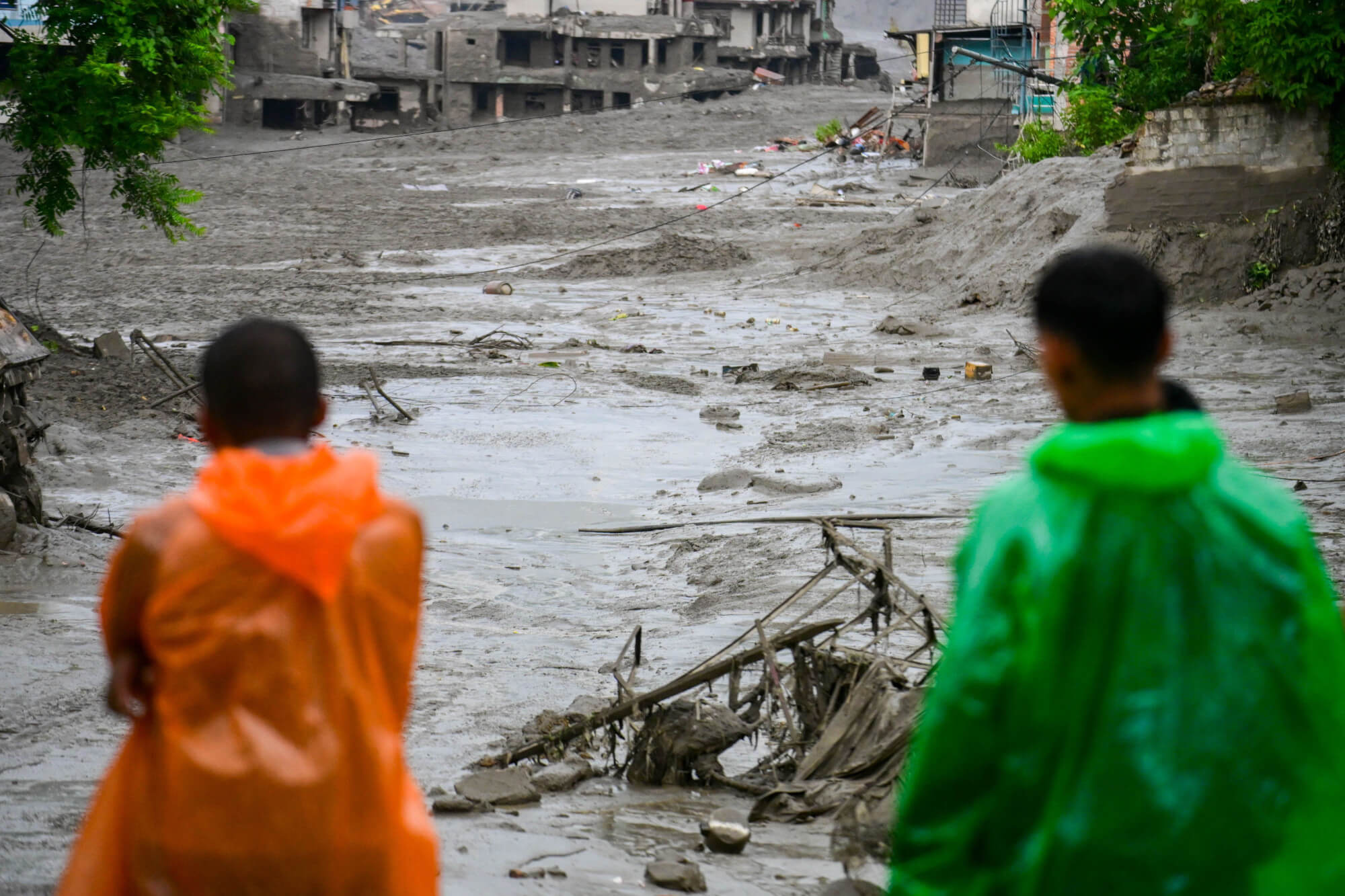 Zwei Menschen stehen nach der Sturzflut in Nepal vor ihren zerstörten Häusern.