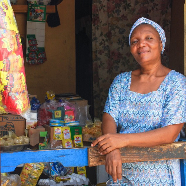 Eine Teilnehmerin einer CARE-Kleinspargruppe in Haiti steht vor ihrem Lebensmittelladen